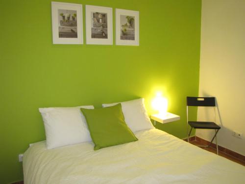 リスボンにあるAppartement calme / Alfamaの緑の壁のベッド付きの緑のベッドルーム1室