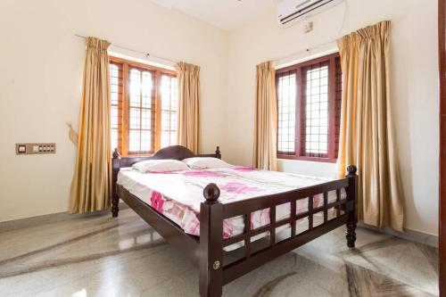 a bedroom with a bed and two windows at Stay at DBRA 61 Don Bosco Cross Road Vaduthala Ernakulam in Cochin