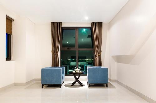 a living room with two blue chairs and a table at Royal Quang Binh Hotel in Dong Hoi