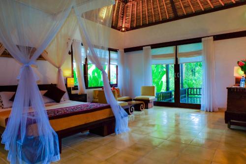 a bedroom with a bed with a mosquito net at Villa Sebali in Ubud
