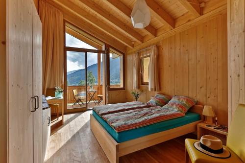 1 dormitorio con cama y ventana grande en BerglandHof Hotel Ernen en Ernen