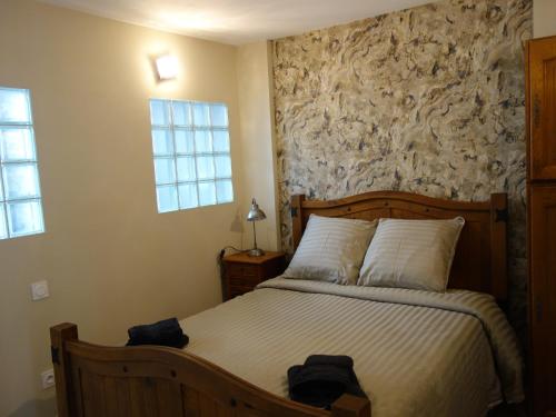 a bedroom with a bed with a stone wall at Armonui Honfleur centre historique in Honfleur