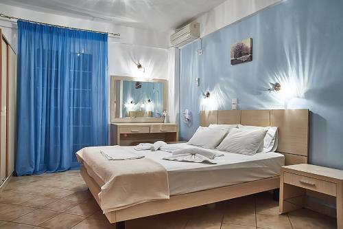 um quarto com uma cama grande e paredes azuis em Villa Aroni em Elafonisos