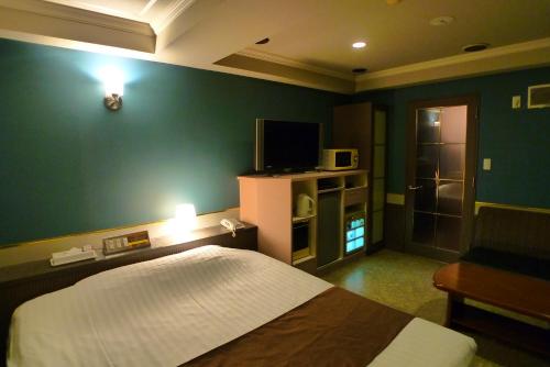 a bedroom with a bed and a green wall at Hotel GOLF III Atsugi (Adult Only) in Atsugi