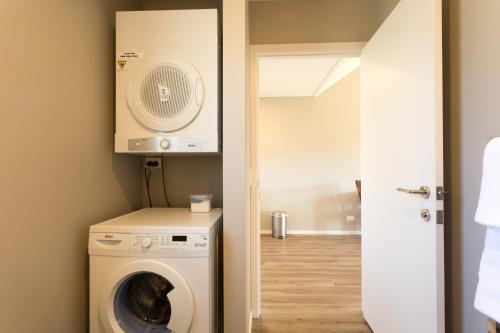a laundry room with a washing machine and a washer at Shotover Country Cottages in Queenstown