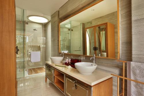 a bathroom with two sinks and a large mirror at Berry Amour Romantic Villas in Seminyak
