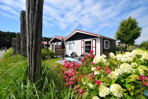 a small house with flowers in front of it at Vakantiepark de Meerpaal in Zoutelande