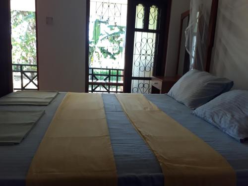 a large bed in a room with a window at Traveller's Home Hotel in Tissamaharama