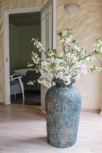 a blue vase with white flowers in a room at Väike-Mere Villa in Haapsalu