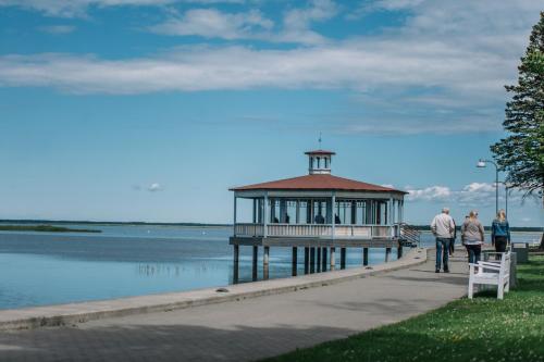 people walking on a pier with a lighthouse on it at Väike-Mere Villa in Haapsalu