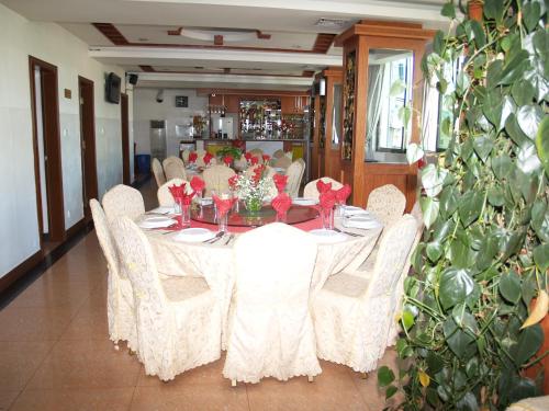 a dining room with a table and white chairs at Evergreen Hotel in Antananarivo