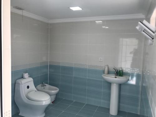 a bathroom with a toilet and a sink at Beaming_House in Sheki