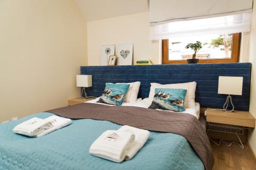 a bedroom with a blue bed with towels on it at Rezydencja Park Rodzinna - FAF in Mielno