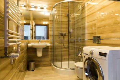 a bathroom with a washing machine and a sink at Rezydencja Park Rodzinna - FAF in Mielno