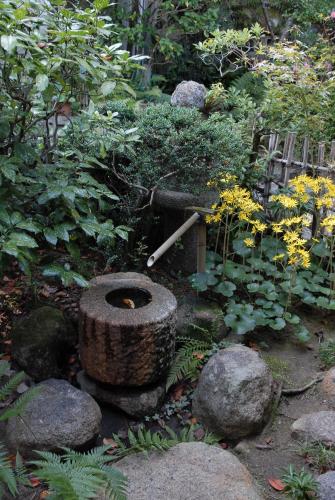 a garden with a large tire and a water fountain at Bingoya in Kurashiki