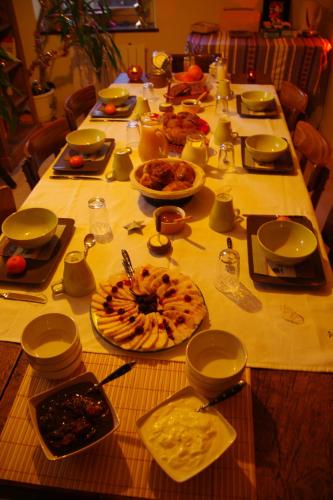 un lungo tavolo con molti piatti di cibo sopra di Les Petits Gallais a Saint-Carreuc