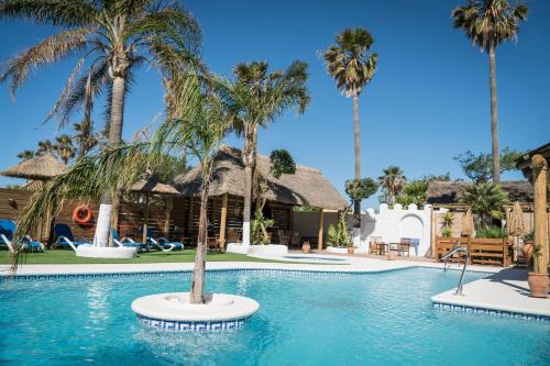 una piscina con palmeras en un complejo en Hacienda Sajorami, en Zahora