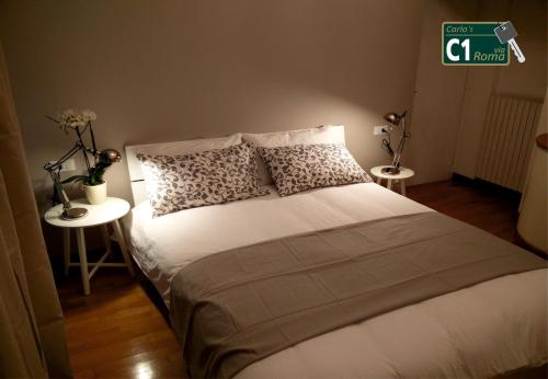 een slaapkamer met een groot bed en 2 tafels bij Carlo's BCC1 - Sanremo Center Suite - da Carlo - in Sanremo