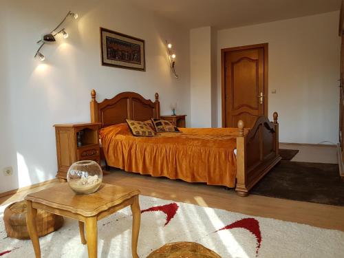 a bedroom with a bed with orange sheets and a table at Ultracentral Bucovina in Gura Humorului