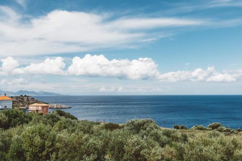 a view of the ocean from a hill with a house at Fexulis Studios & Suites in Agios Nikolaos