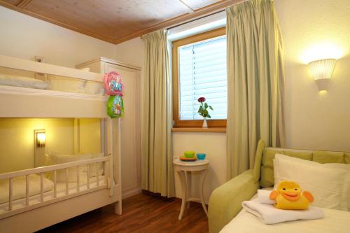 a bedroom with a bunk bed and a yellow duck on a pillow at Landvilla Romantika in Lermoos