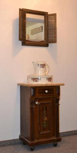 a wooden table with a mirror on a wall at Gästehaus-Pension Barbara in Andelsbuch