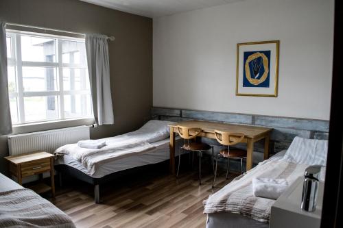 ブーザルダールルにあるダーラコット ブーダルダシのベッド2台、テーブル、窓が備わる客室です。