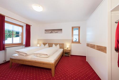 una camera con letto e tappeto rosso di Appartement Doris a Schröcken