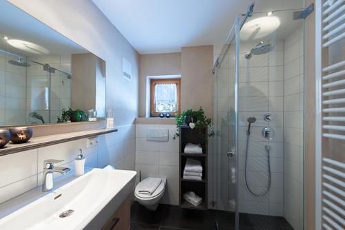 uma casa de banho com um chuveiro, um WC e um lavatório. em Appartement Doris em Schröcken