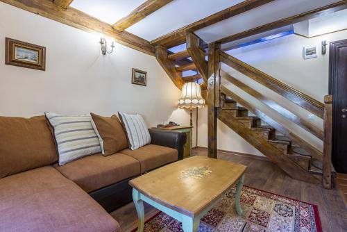a living room with a couch and a staircase at Resort Ambient in Cristian