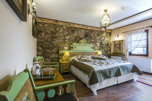 a bedroom with a bed and a stone wall at Resort Ambient in Cristian