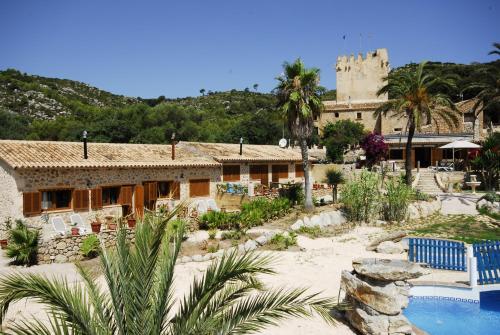 een resort met een gebouw en een zwembad bij Finca Sa Duaia de Dalt in Artá