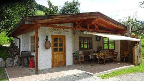 a small house with a table and an umbrella at Zachhof in Ellbögen