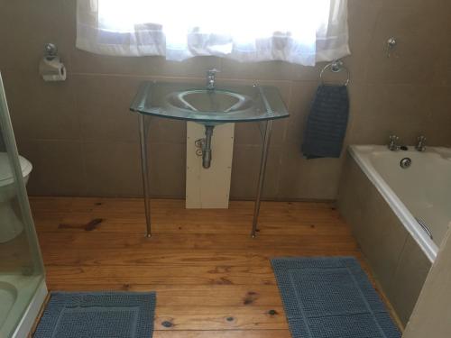 a bathroom with a sink and a bath tub at Bridal Drift Cottage in Colenso