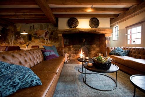 a living room with a couch and a fireplace at Herberg de Gouden Leeuw in Bronkhorst