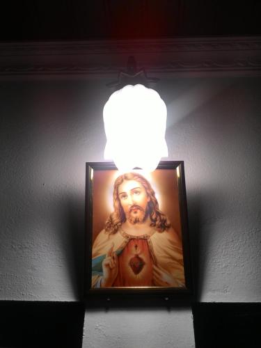 a light hanging from a wall with a painting of builder at Marari Babu Homestay in Mararikulam