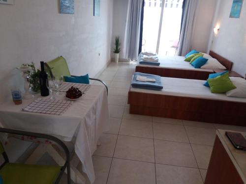 a hotel room with two beds and a table with a table sidx sidx at Apartments Boris in Omiš