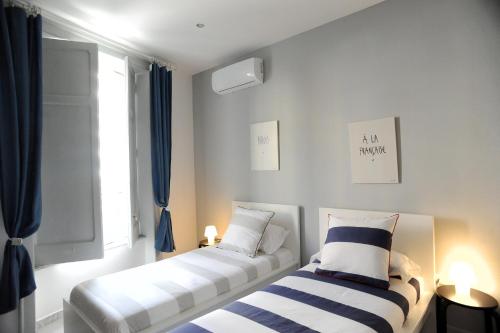 dwa łóżka siedzące obok okna w pokoju w obiekcie Maison Salerno w mieście Salerno