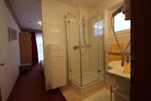 a bathroom with a shower and a sink at Hotel Garni Lärchenhof in Lech am Arlberg