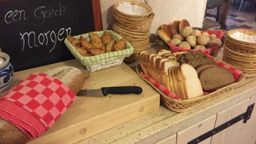 a counter with bread and baskets of different types of bread at Hotel De Oude Brouwerij in Mechelen