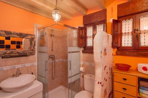 a bathroom with a shower and a toilet and a sink at El Cierruco in Santillana del Mar