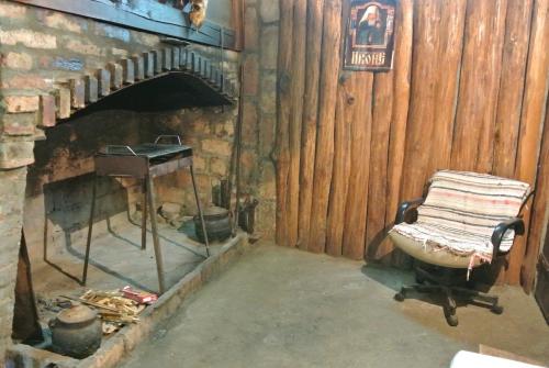 a room with a chair in front of a fireplace at Apartmani Mali Raj Rudnik in Rudnik Kačerski