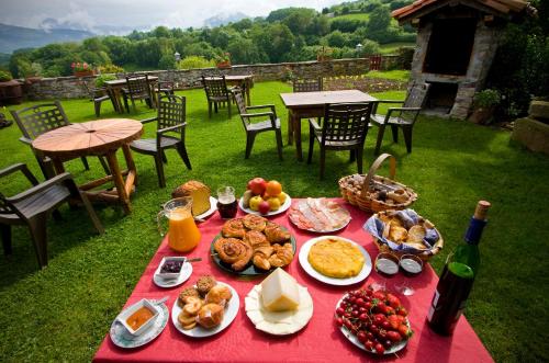 - une table rouge avec de la nourriture et une bouteille de vin dans l'établissement Casa Rural Zigako Etxezuria, à Ziga