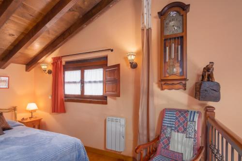 a bedroom with a bed and a clock on the wall at El Cierruco in Santillana del Mar