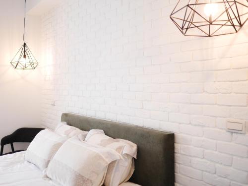 a bedroom with white walls and a bed with white pillows at Chu V B&B in Yuanshan