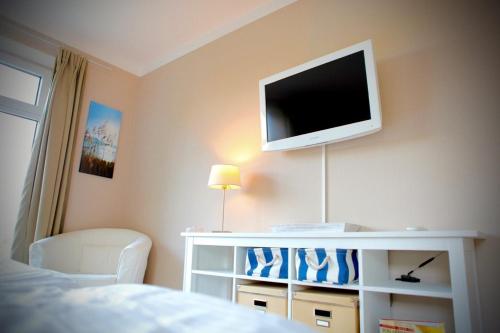 a bedroom with a flat screen tv on the wall at Kieler FeWo No.2 in Kiel