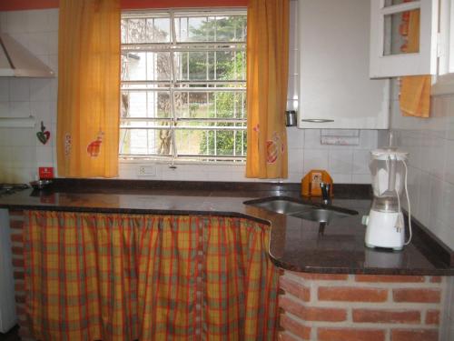 a kitchen with a counter top and a window at La casa de Almirall in Santa Rosa de Calamuchita