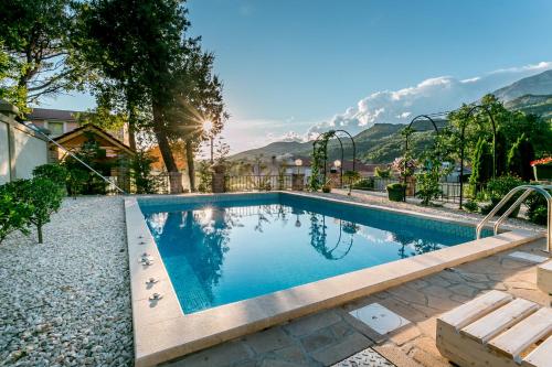 a swimming pool with mountains in the background at Villa Besha in Herceg-Novi