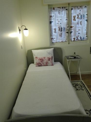 a bed in a room with a lamp and a window at Ester Guest House in Chaves