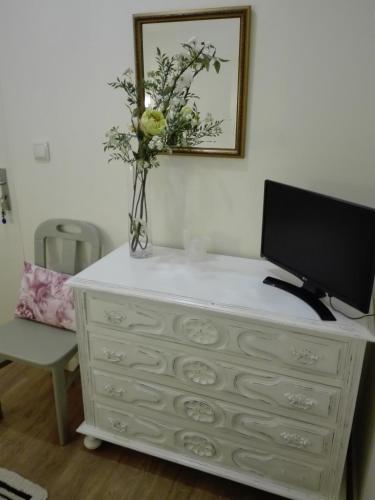a white dresser with a tv on top of it at Ester Guest House in Chaves
